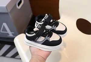 Detailed view of stylish black and white children's thick-sole casual sneakers with velcro
