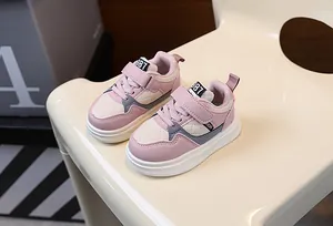 Detailed view of pink and beige toddler sneakers with thick soles and velcro straps.