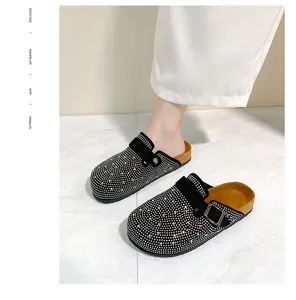 Elegant black rhinestone-embellished clogs with buckle strap and cork sole detail