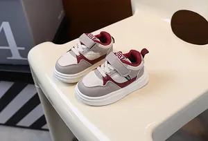 A detailed view of stylish children's thick-sole casual sneakers in beige and burgundy