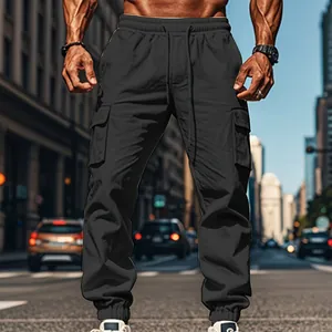 Close-up of men's black cargo joggers with drawstring waist in urban street setting