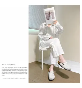 White rhinestone closed-toe mules worn by a model in a minimalist lifestyle setting