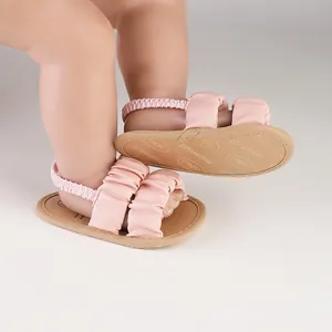 Close-up view showing the gathered straps and soft sole design of these pink baby sandals
