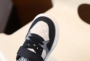 Close-up of stylish children's sneakers showing quilted toe area and 1987 print details