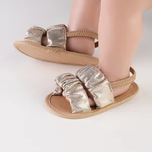 Detailed view of shimmering gold cloud-design baby sandals with soft soles