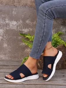Sandales bleues en maille Fly-knit à semelle épaisse présentées sur les pieds du modèle