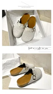 Detail view of sparkly rhinestone platform clogs in a luxury white gift box presentation.