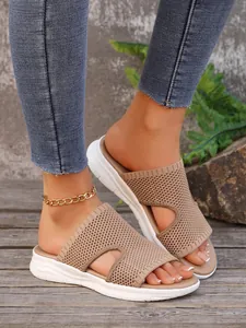 Vue détaillée des mules à plateforme en maille kaki pour femmes sur terrasse bois.
