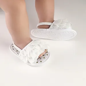 Close-up of white ruffled baby walker shoes with elastic strap and polka dot insole