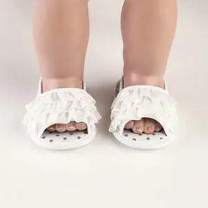 Detail view of white tiered ruffle baby walking sandals with gold polka dot insoles