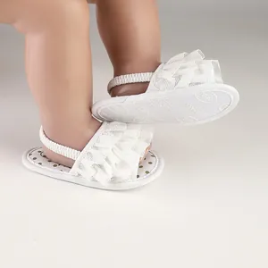 Close-up of white ruffled baby prewalker sandals with elastic strap on baby feet