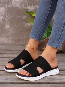 Gros plan de mules à plateforme pour femmes en maille noire avec détails ajourés