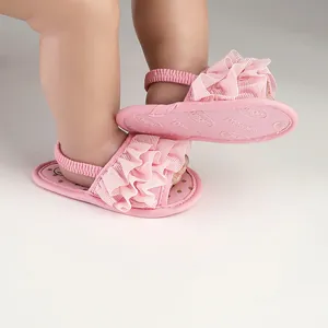 Close-up of pink baby prewalker walking shoes with ruffle design and elastic back strap.