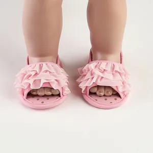 Macro detail of cute pink ruffle baby pre-walker sandals featuring soft polka dot soles.