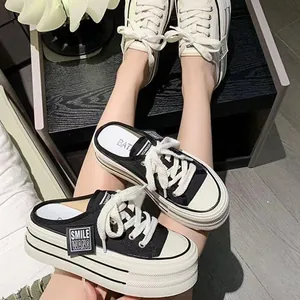 Detail view of stylish black and white platform mule sneakers with Smile Wang label
