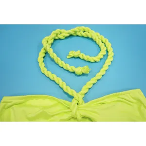 Nahaufnahme eines neongrünen, geflochtenen Seil-Neckholders an einem trendigen Bandagenkleid