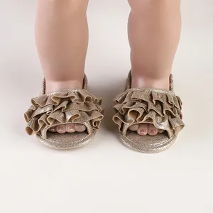 Close-up of elegant golden ruffled baby walking sandals for infants aged 0 to 1 year.