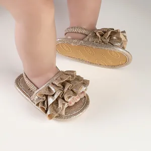 Detailed view of gold ruffled baby prewalker shoes with flexible elastic strap.