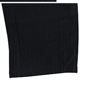 Vista detallada del dobladillo de unos pantalones de trabajo negros anchos para hombre.