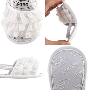 Detailed close-up of white ruffled breathable baby sandals with soft prewalker soles