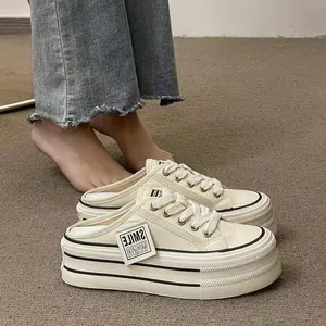 Detail view of stylish beige platform mule sneakers with thick soles and mesh upper