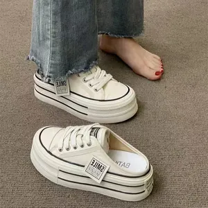 Detail view of breathable white mesh platform mule sneakers with chunky striped soles.