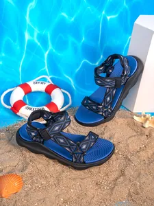 Vista dettagliata dei sandali da spiaggia blu antiscivolo da bambino sulla sabbia