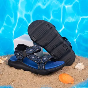 Vista dettagliata dei sandali da spiaggia blu antiscivolo per bambini sulla sabbia.