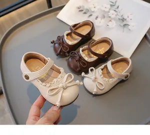 Gros plan d'une chaussure beige pour fille avec noeud et semelle souple en détail