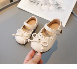 Chaussures Mary Jane blanc cassé pour fille avec nœud élégant et bordure dentelle.
