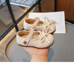 Détail de chaussures Mary Jane beiges pour filles avec nœud délicat et bordure en dentelle