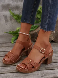 Detailansicht brauner Sandalen mit Blockabsatz, Lochmustern und Knöchelriemen mit Schnalle