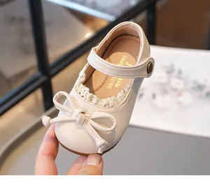Gros plan de chaussures de princesse beiges pour filles avec un nœud et de la dentelle.
