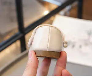 Gros plan sur la couture et la semelle souple d'une chaussure de princesse blanche pour fille.