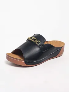Vista dettagliata del sandalo con zeppa nero da donna con decorazione a catena d'oro di stile