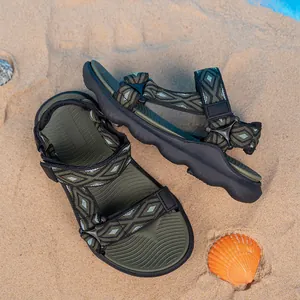 Dettaglio di sandali da spiaggia antiscivolo da bambino con motivi geometrici sulla sabbia.