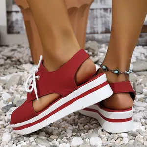 Red platform lace-up sandals with peep toe design for women shown on a pebble beach.