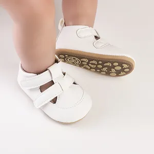 Detaillierte Nahaufnahme von weißen Lauflernsandals mit weicher Sohle und Fußmustern