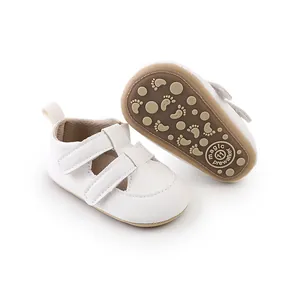 Weiße Baby-Lauflernschuhe aus Kunstleder mit rutschfester Sohle und Fußabdruckmustern.