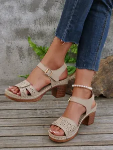 Detailansicht eleganter beiger Sandalen mit Blockabsatz, Hohlmustern und Knöchelriemen