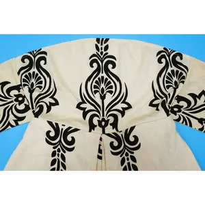 Detailed view of black damask pattern on a cream strapless romper jumpsuit fabric.