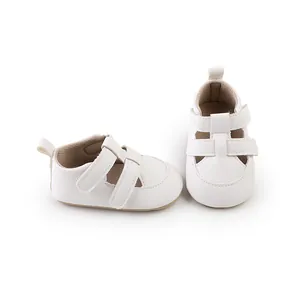Nahaufnahme von weißen, atmungsaktiven Baby-Lauflernschuhen mit doppeltem Klettverschluss.