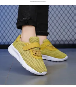 Vista lateral detallada de zapatillas de malla amarilla transpirable para niñas con suela blanca