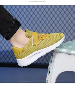 Vista lateral de zapatillas de running amarillas para niñas con malla transpirable
