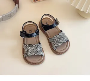 Détail des lanières tressées en strass sur sandales noires pour filles
