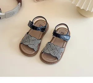 Détail de sandales noires pour filles avec des lanières tressées en strass argentés