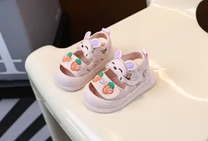 Vue détaillée des sandales roses pour bébé avec de mignons motifs lapin et carotte