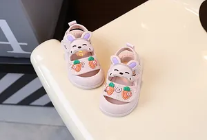 Détail des sandales roses pour bébé avec des décorations de lapin et de carotte