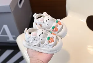 Gros plan de sandales blanches pour bébé avec décors de lapin et carotte