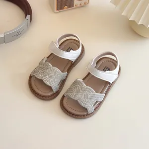 Sandales blanches élégantes pour filles avec brides en strass tissés et semelle souple.
